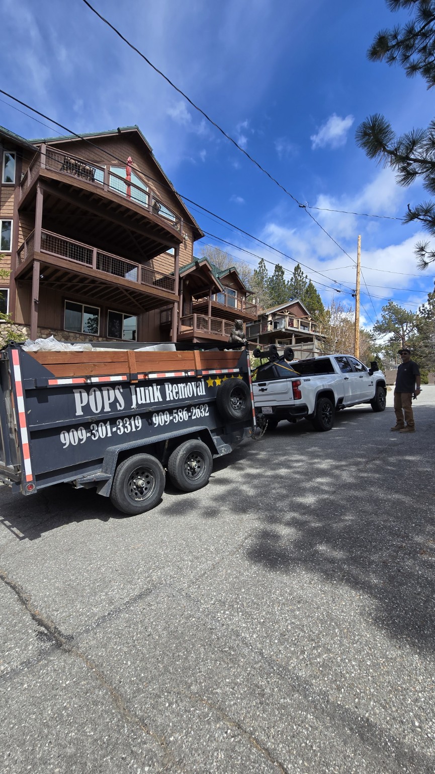 Pop's Junk Removal truck and dump trailer at a job site